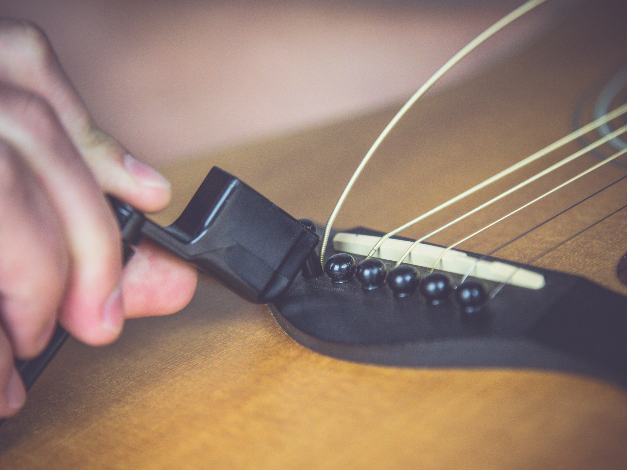 Pins am Steg der Gitarre lösen